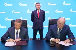 Кирилл Комаров и Виталий Маркелов во время подписания, на заднем плане — Алексей Миллер