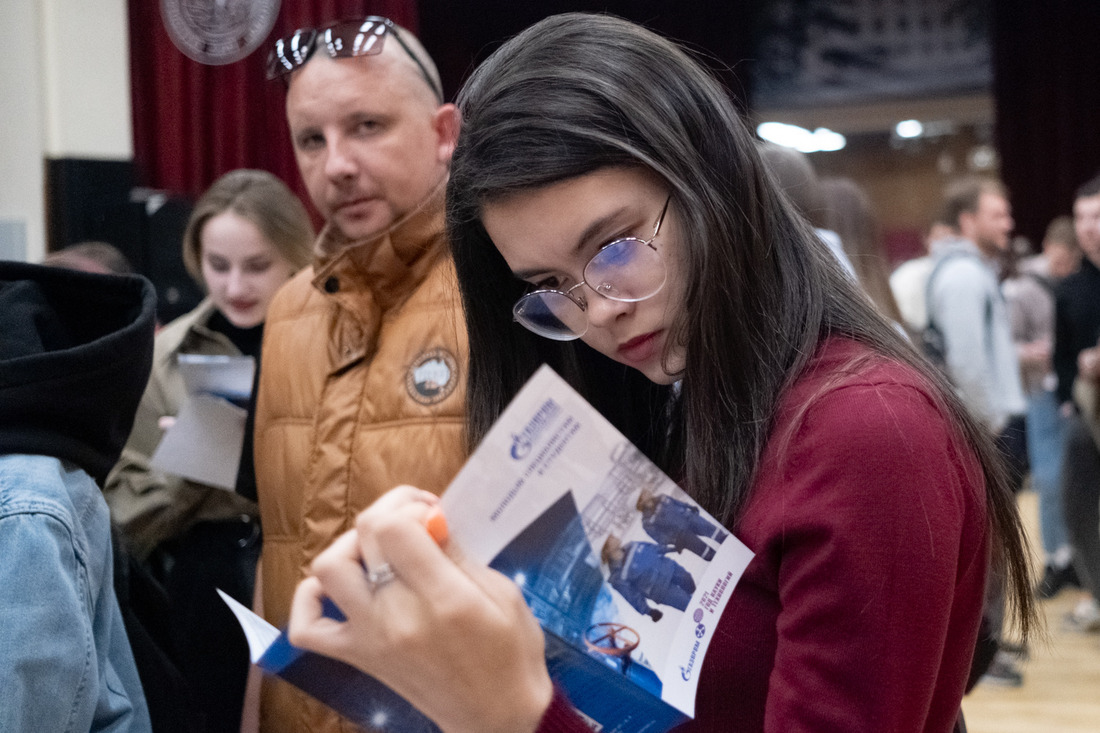 студентка с буклетом "Газпром добыча шельф Южно-Сахалинск", посвященным практике и трудоустройству в компании